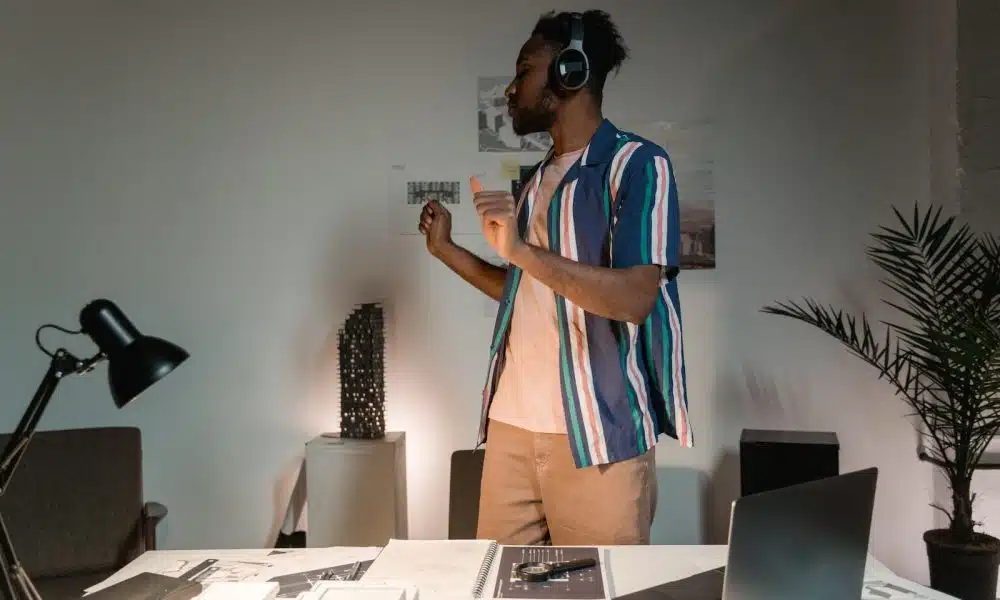 A Man Wearing Headphones Dancing Near White Wooden Tablle