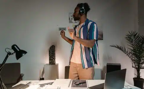 A Man Wearing Headphones Dancing Near White Wooden Tablle