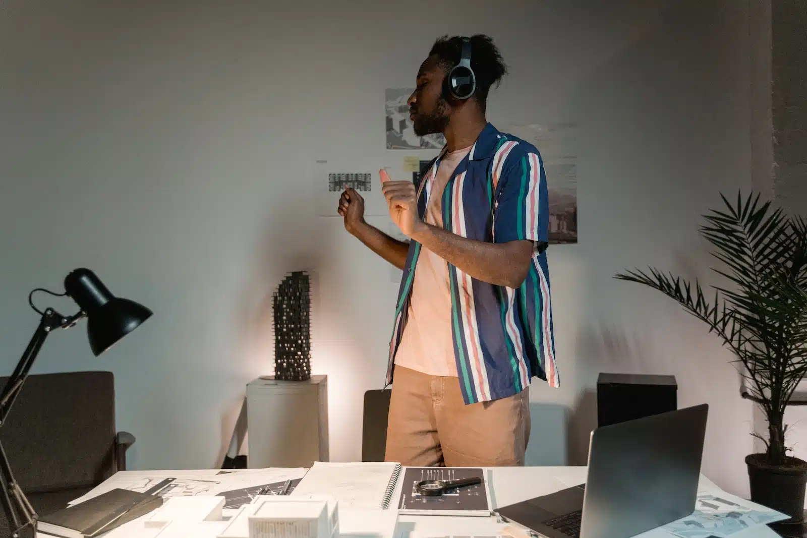A Man Wearing Headphones Dancing Near White Wooden Tablle