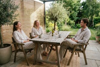 Groupe d'amis autour d'une table en terrasse en été
