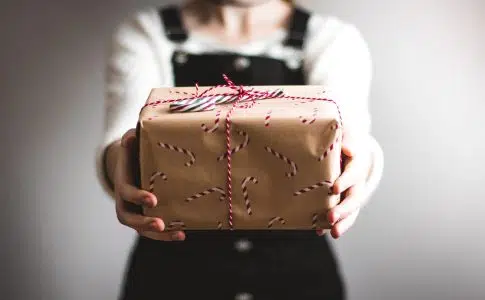 person showing brown gift box